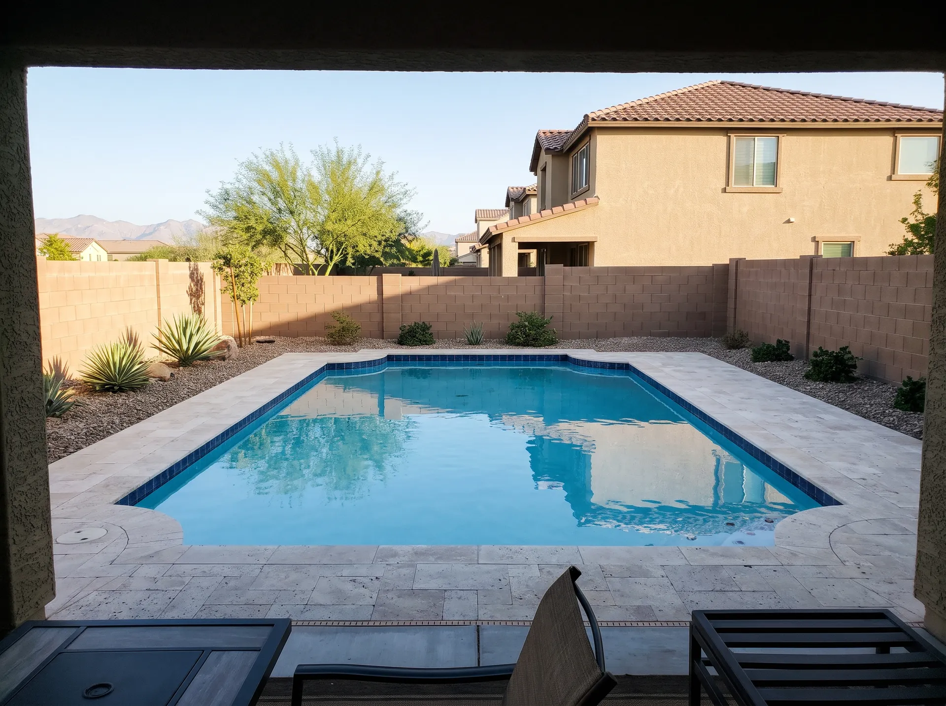 Backyard pool with clear water and a clean tile line after a weekly service visit